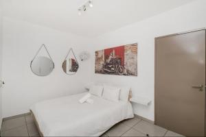 a white bedroom with a bed and a mirror at Soho Junction fourways in Sandton