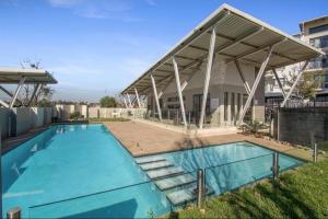a swimming pool with a pavilion on top of a house at Soho Junction fourways in Sandton