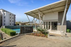 a building with a swimming pool and a sign at Soho Junction fourways in Sandton +4 photos