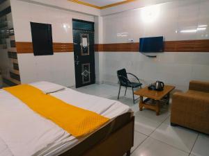 a bedroom with a bed and a table and a chair at S D palace in Dighori