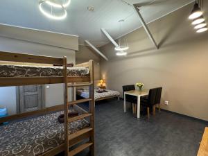 a room with bunk beds and a table and a desk at Marbella in Ventspils