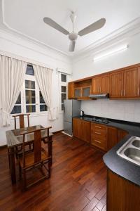 a kitchen with wooden cabinets and a table and a ceiling at Davidduc Villa 30 Tay Ho in Hanoi