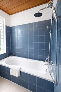 a blue tiled bathroom with a bath tub at Davidduc Villa 30 Tay Ho in Hanoi +22 photos