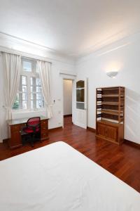 a white bedroom with a desk and a bed at Davidduc Villa 30 Tay Ho in Hanoi