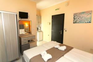 a bedroom with two white towels on a bed at Oliva Resort View & Swimming pool Studios in Parga