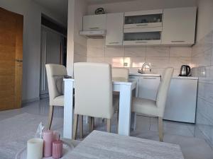 a kitchen with a table and chairs in a room at Apartman Sunce in Bosanska Gradiška +10 photos