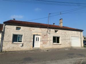 a brick house with a white door and two windows at Chambre cosy avec salle de bain privée et piscine au calme in Saint-Sylvestre-sur-Lot