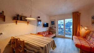 a living room with a table and chairs and a balcony at Appartement Flaine Forêt in Flaine