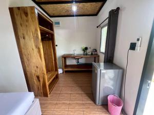 a hallway with a refrigerator and a table in a room at Lanta Baan Suan Yoo Dee in Ban Nong Chaeng