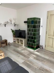 a living room with a tv and a green brick fireplace at Chalupa Hlohovec in Hlohovec
