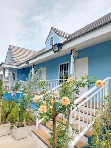 a blue house with flowers on the stairs at เจอาร์รีสอร์ท ที่พักบ้านมุงเนินมะปราง in Ban Mung +11 photos