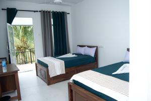 a bedroom with two beds and a balcony at Rainforest Jungle Chill Singharaja in Deniyaya