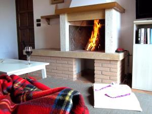 a fireplace in a living room with a fire in it at Casamorena in Montegabbione