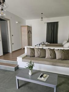 a large bed in a white room with a table at Aegean Muses in Leipsoi