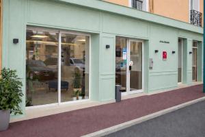 a store front with glass doors in a building at Hotel Parisien in Menton