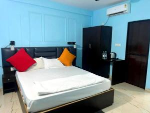 ein Schlafzimmer mit einem Bett mit bunten Kissen in der Unterkunft Hotel The B House Goa in Agonda