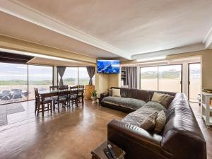 a living room with a couch and a dining room with a table at Ganstever Suiderstrand Western Cape in Suiderstrand