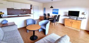 a living room with a couch and a table and chairs at Boddenhof Apartment 48 - Terrasse für Hundefreunde in Buschvitz
