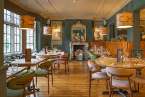 a dining room with tables and chairs and a fireplace at The Wheatsheaf Hotel, Sandbach in Sandbach
