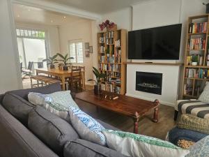 a living room with a couch and a tv at Cherry Tree House, Newlands in Cape Town