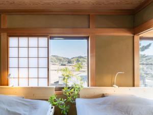 a bedroom with a window and a bed with white pillows at Guesthouse NAMAZU in Anan