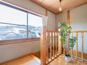 a room with a large window and a potted plant at Guesthouse NAMAZU in Anan