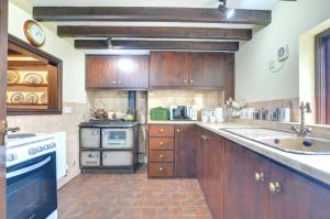 a kitchen with wooden cabinets and a stove and a sink at 2 Bed in Porthcawl oc-way245 in Porthcawl +6 photos
