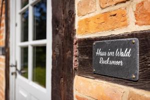 a sign on a brick wall next to a door at Haus im Wald in Gartow