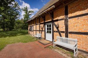 a brick building with a white door and a bench at Haus im Wald in Gartow
