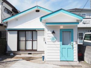 a white and blue house with a blue door at アンドスティ鴨川 in Kamogawa