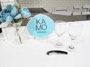 a table with two wine glasses and a sign that says ka no preference at アンドスティ鴨川 in Kamogawa