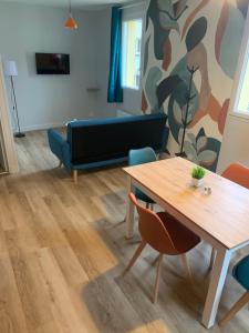 a living room with a table and a couch at Résidence Saint Pôl in Nogent-le-Rotrou