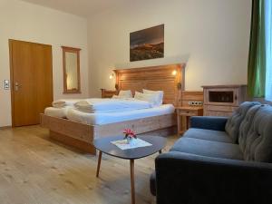a hotel room with a bed and a couch at Dom-Hotel in St. Blasien