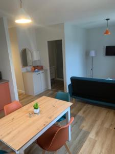 a living room with a table and a couch at Résidence Saint Pôl in Nogent-le-Rotrou