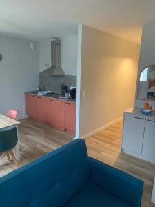 a living room with a blue couch and a kitchen at Résidence Saint Pôl in Nogent-le-Rotrou +38 photos