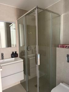 a glass shower in a bathroom with a sink at Live Lugano - Via Muggina in Viganello +28 photos
