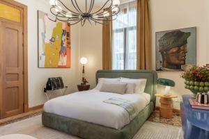 a bedroom with a bed and a chandelier at Maison DADA in Beirut