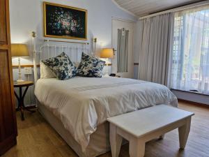 a bedroom with a large white bed and a window at Old Oak Guest House in Bellville +38 photos