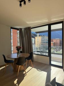 a dining room with a table and a large window at Live Lugano - Via Muggina in Viganello