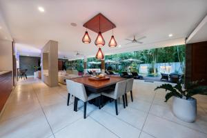 a dining room and living room with a table and chairs at The Muse Luxury Eco-Living in Munggu