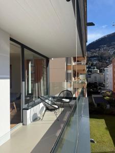 a balcony with two chairs and a view of a city at Live Lugano - Via Muggina in Viganello
