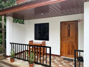 a house with a porch with a wooden door at JoRich Guest House in Siquijor
