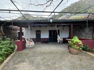 a porch of a house with a swing at Casa da Torre in Porto Moniz