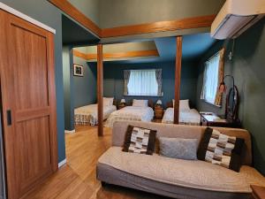 a living room with two beds and a couch at Pension Green Lake in Gujo