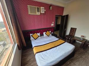 a bedroom with a bed and a red wall at Hotel Ganges Park in Haridwār +20 photos