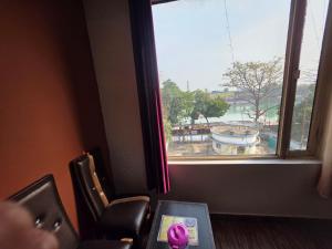 a room with a window with a view of a fountain at Hotel Ganges Park in Haridwār