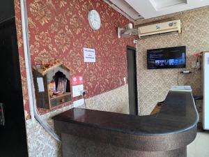a bar in a room with a clock on a wall at Hotel Ganges Park in Haridwār