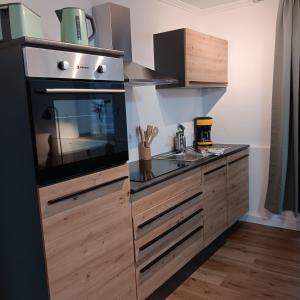 a kitchen with a stove and a sink at Ferienwohnung Grünes Leben in Simmerath