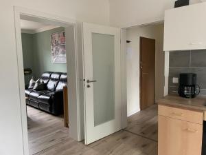a kitchen with a door open to a living room at City Wohnung in Haltern gratis Parken, Netflix & Wäschepaket in Haltern