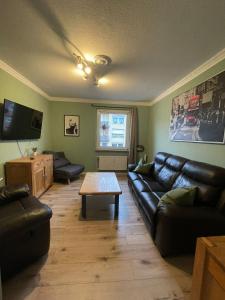 a living room with a leather couch and a coffee table at City Wohnung in Haltern gratis Parken, Netflix & Wäschepaket in Haltern